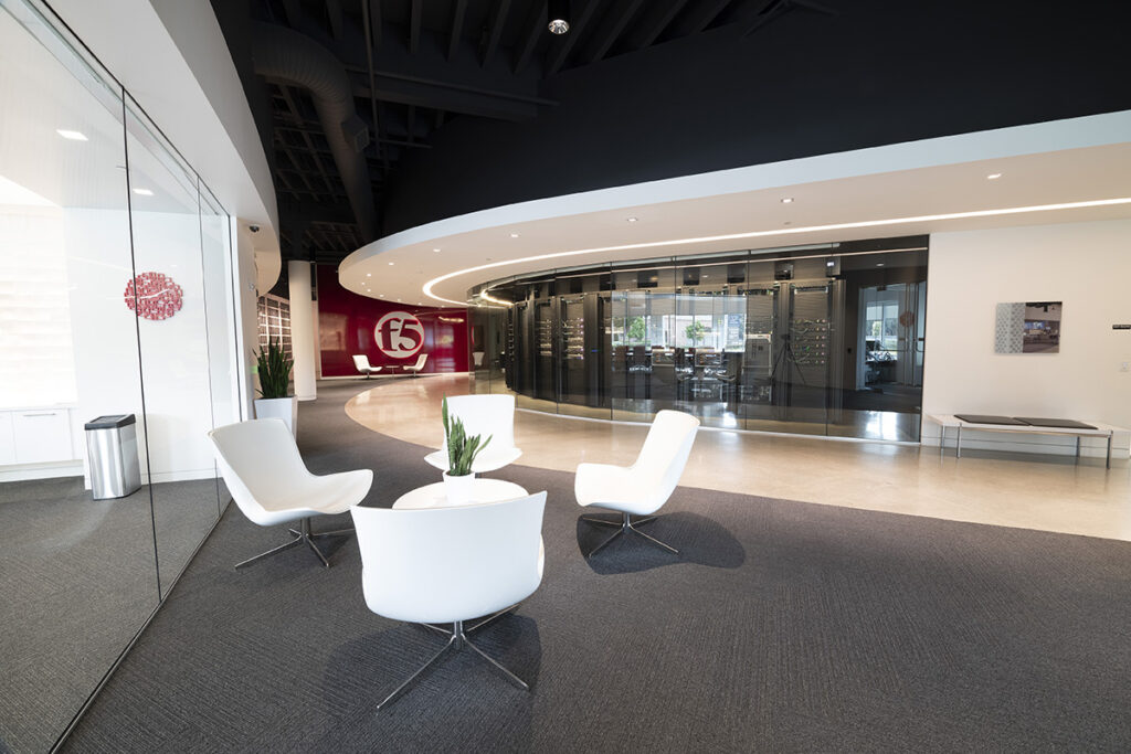 Modern interior office lobby carpeted with white upholstered chairs